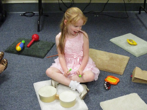 A child is having fun at the Music station